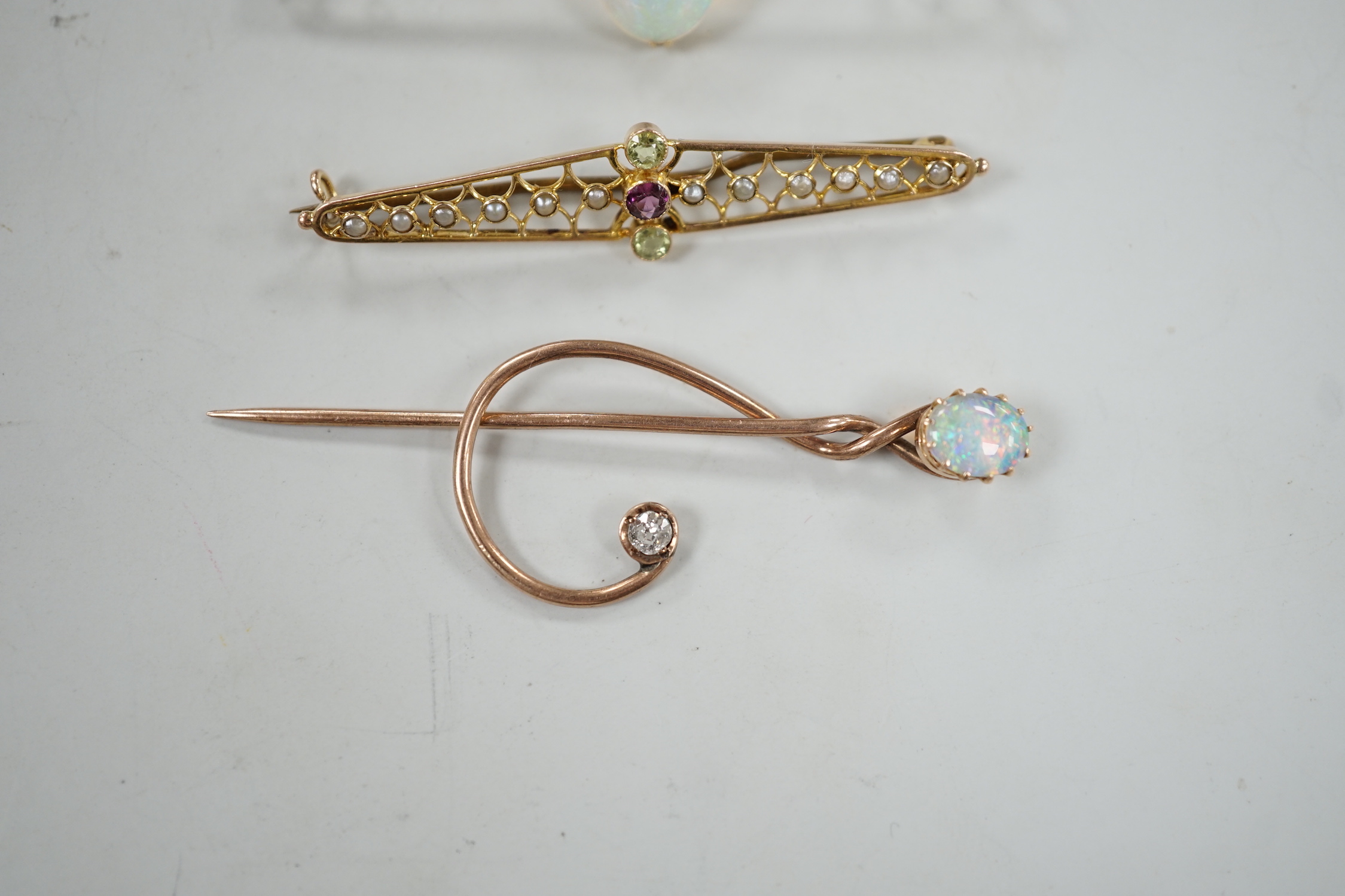 A novelty yellow metal, white opal and diamond set 'treble clef' stick pin, 60mm, a 15ct and white opal set bar brooch and one other 9ct and gem set brooch, gross weight 8.2 grams.